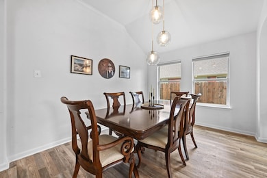 Dining space featuring vaulted ceiling and light wood-style flooring