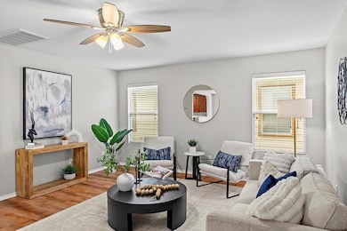 Sitting room with visible vents, a ceiling fan, b