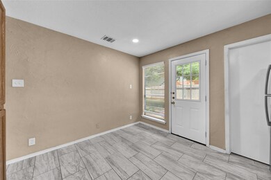 Doorway featuring baseboards, a textured wall, an