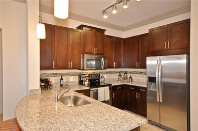 Kitchen featuring backsplash, track lighting, appliances with stainless steel finishes, and sink