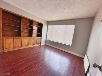 Spare room featuring a textured ceiling, dark wood