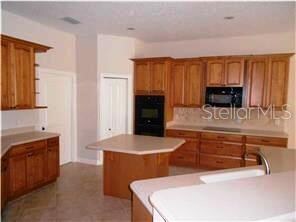 Kitchen boasts Island, Double Ovens, microwave, Corian Countertops, Walk-In Pantry.