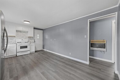 Kitchen featuring white cabinets, dark hardwood / wood-style flooring, white gas stove, backsplash, and stainless steel fridge with ice dispenser
