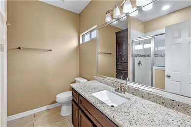 Full bathroom featuring a stall shower, vanity, and tile patterned flooring