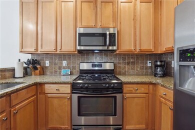 Kitchen with light stone countertops, appliances w