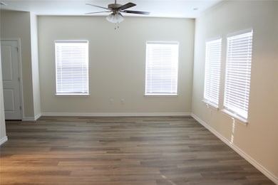 Spare room with ceiling fan, dark wood-type floor