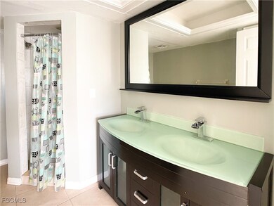 Bathroom featuring double vanity, a stall shower, and light tile patterned flooring