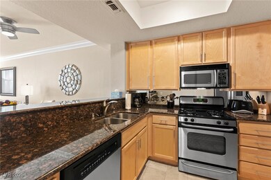 Kitchen with a sink, visible vents, light brown ca