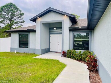 Entrance to property with roof with shingles and stucco siding
