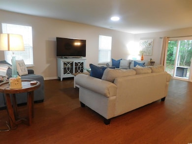 Living room featuring dark wood finished floors, baseboards, and recessed lighting