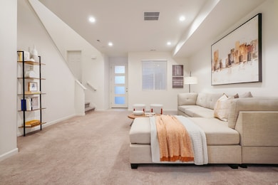 Carpeted living area featuring stairway and recessed lighting