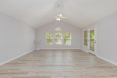 Empty room with light wood-style floors, ceiling fan, baseboards, and vaulted ceiling