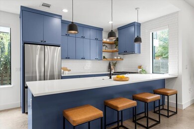 Kitchen with blue cabinetry, baseboards, freestan