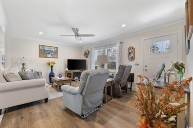 Living room with ornamental molding, light wood-ty