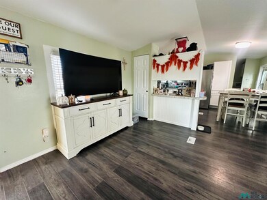 Living room with dark wood-style floors and baseboards