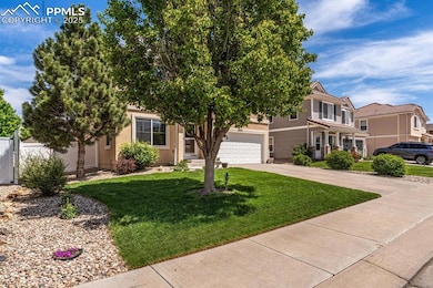 View of property hidden behind natural elements with concrete driveway, a garage, and a front yard