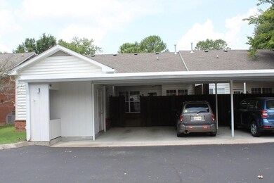 2 car carport with trash bin on the side and entrance to workshop
