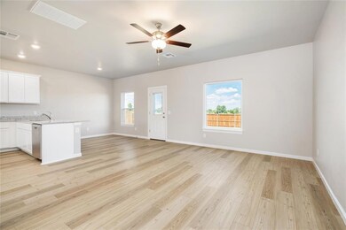 The open-concept living area features luxury vinyl