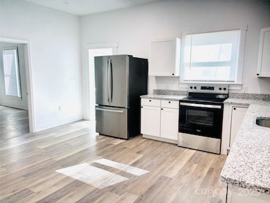 Open concept kitchen with granite countertops and modern appliances.