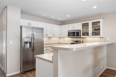 Kitchen with white cabinetry, dark wood-type floor