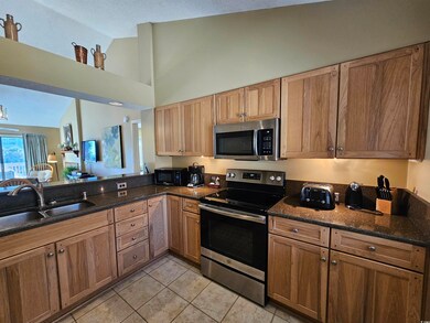 Kitchen featuring sink, dark stone countertops, li