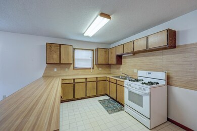 Kitchen with sink, white range with gas cooktop, a textured ceiling, and light tile flooring
