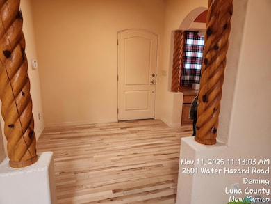 Spare room with arched walkways and light wood-style floors