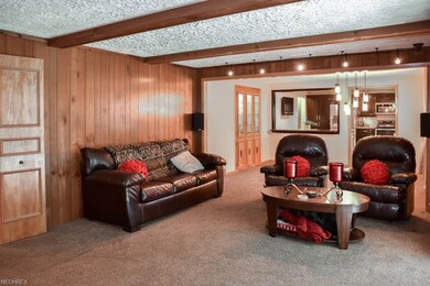 The great room, with wood beams, is open to the di