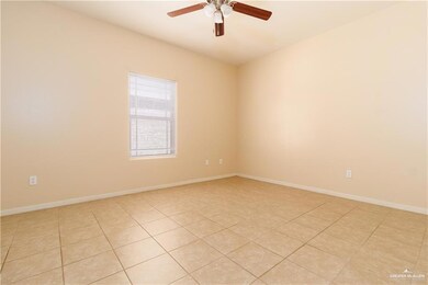 Empty room with light tile patterned floors and a ceiling fan