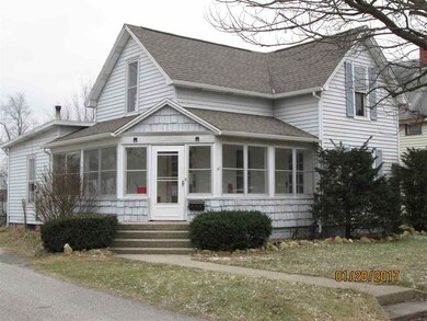 Enclosed front porch wraps around front door area.