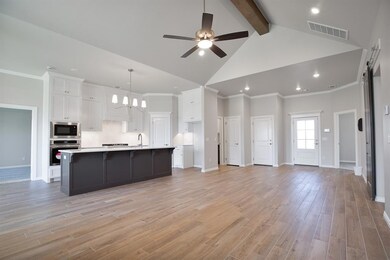 Kitchen with a center island with sink, ceiling fa