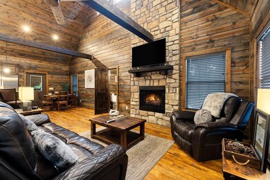 Living area with high vaulted ceiling, wooden walls, hardwood / wood-style flooring, and a fireplace