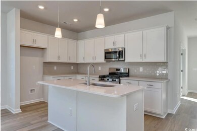 Kitchen with white cabinetry, a kitchen island wit