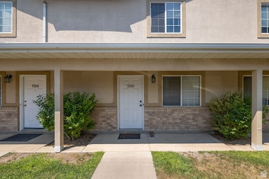 Doorway to property with brick siding, stucco siding, and covered porch