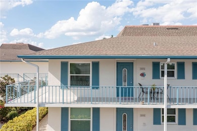 View of front of home with a shingled roof, stucco siding, and a balcony