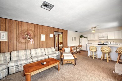 Living room with ceiling fan and wood walls