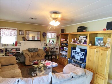 Living area with mock fireplace behind chair.