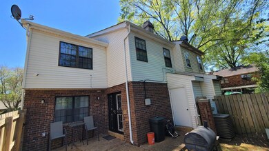Rear view of house featuring fence, brick siding, and central AC