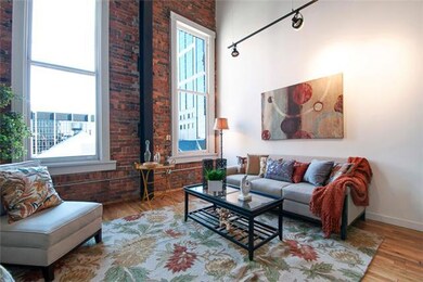 The beautiful living room is generously sized with a great layout, and overlooks the Arcade and city life below. 