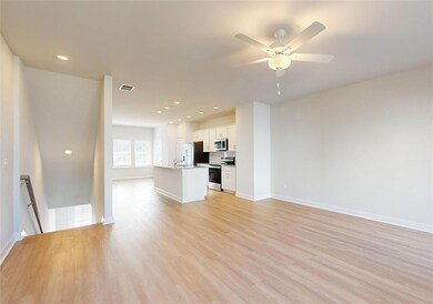 Unfurnished living room with ceiling fan, light ha