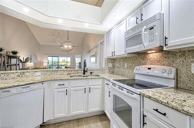 Kitchen with an inviting chandelier, white applian