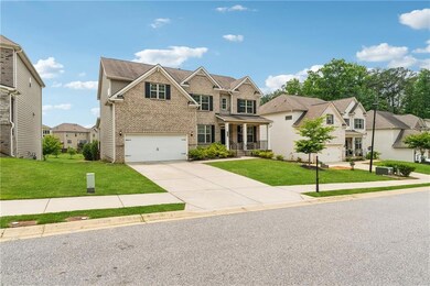 View of front of house featuring brick siding, a front yard, driveway, a residential view, and an attached garage