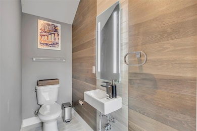 Bathroom with wood walls, baseboards, and toilet