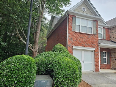 View of front of house with brick siding, driveway, an attached garage, and a shingled roof