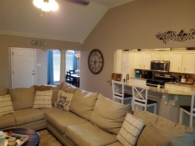Open living room with column and vaulted ceiling.