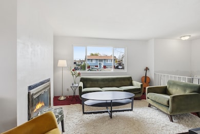 Large open living room with fireplace, lots of natural light and neutral paint.