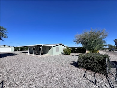 Rear view of house featuring an outbuilding and a patio area