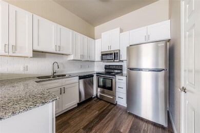 Kitchen featuring light stone countertops, dark w