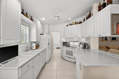 Kitchen with a ceiling fan, a sink, light tile pat