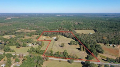 Aerial view of property and surrounding area featuring a heavily wooded area and property parcel outlined